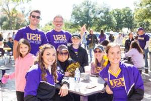 Family sitting at the Homecoming tailgate posed for a photo